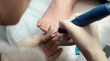 Pedikür ustası, küçük ayaklı güzel bir kıza temizlik ve masaj yapar. Bir prosedür sırasında güzellik salonunda kadın güzelliğiyle ilgilenmek. Ayak ve ayak parmaklarının derisi yakın plan. Yüksek