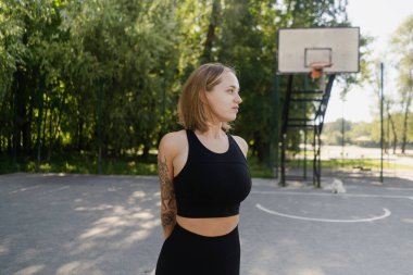 Tozluklu güzel genç atletik kız yazın plajda basketbol sahasında sabah antrenmanında model figürüyle. Fitness, ısınma ve açık hava sporları. Güzellik ve sağlık. Yüksek kalite 4k görüntü