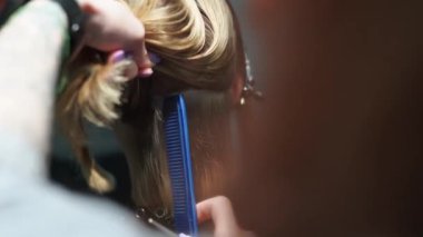 Kısa saçlı ve kısa saçlı güzel bir kız güzellik salonunda bir prosedür uyguluyor. Saç ustası müşterinin saçını boyuyor ve tonu ayarlıyor.