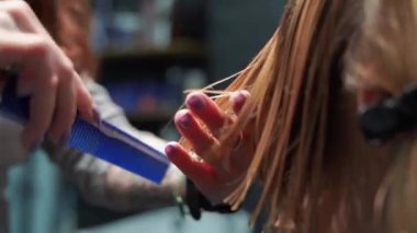 Kısa saçlı ve kısa saçlı güzel bir kız güzellik salonunda bir prosedür uyguluyor. Saç ustası müşterinin saçını boyuyor ve tonu ayarlıyor.