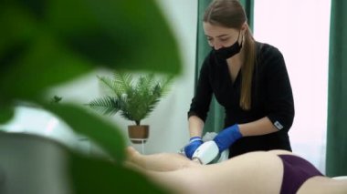 Güzel, genç, seksi bir kız, güzellik salonunda lazer kılları alıyor, koltuk altlarını ve kollarını çıkarıyor, kendine özen ve güzellik, epilasyon ve güzel bir vücut.