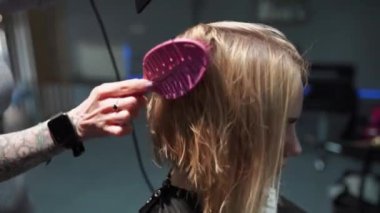 Kısa saçlı ve kısa saçlı güzel bir kız güzellik salonunda bir prosedür uyguluyor. Saç ustası müşterilere saç boyama ve tonu sunuyor. Yüksek kaliteli FullHD görüntüler