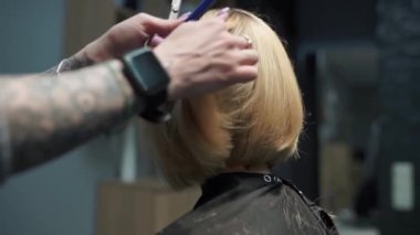 Kısa saçlı ve kısa saçlı güzel bir kız güzellik salonunda bir prosedür uyguluyor. Saç ustası müşterilere saç boyama ve tonu sunuyor. Yüksek kaliteli FullHD görüntüler