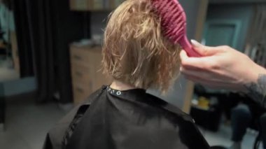 Kısa saçlı ve kısa saçlı güzel bir kız güzellik salonunda bir prosedür uyguluyor. Saç ustası müşterilere saç boyama ve tonu sunuyor. Yüksek kaliteli FullHD görüntüler