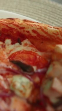 Etli ve peynirli lezzetli iştah açıcı pizza sebzeli bir tabakta yatıyor. Sağlıklı ya da sağlıksız yiyecekler. Taze sağlıklı havuç, yeşillik, brokoli, lahana.