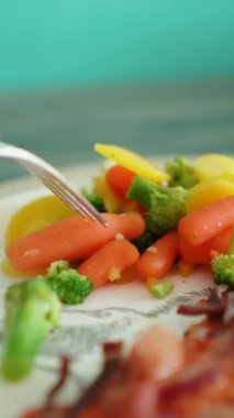 Etli ve peynirli lezzetli iştah açıcı pizza sebzeli bir tabakta yatıyor. Sağlıklı ya da sağlıksız yiyecekler. Taze sağlıklı havuç, yeşillik, brokoli, lahana.