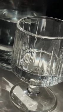 Cam ve kristalden yapılmış temiz su bardaklarının yakın çekimi. Güneş ışınları camda parlıyor. Restoran ve kafe