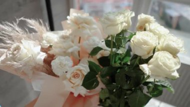 Evin penceresinin yanında güzel bir buket beyaz gül duruyor. Tatildeki bir kız için romantik bir hediye. Çiçek.