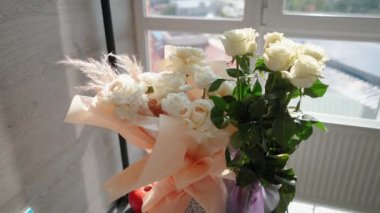 Evin penceresinin yanında güzel bir buket beyaz gül duruyor. Tatildeki bir kız için romantik bir hediye. Çiçek.