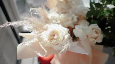 Evin penceresinin yanında güzel bir buket beyaz gül duruyor. Tatildeki bir kız için romantik bir hediye. Çiçek.