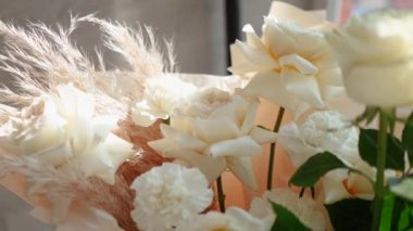 Evin penceresinin yanında güzel bir buket beyaz gül duruyor. Tatildeki bir kız için romantik bir hediye. Çiçek.