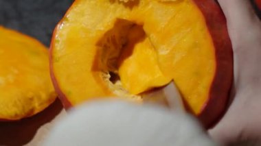 Cadılar Bayramı 'nda balkabağı parlar. Mutfaktaki kız masaya lezzetli bir portakal kabağı kesiyor. Hayalet, korku ve kutsal bayram dekoru.