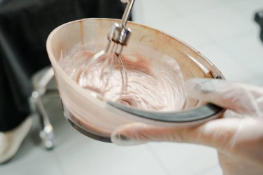 Kısa saçlı ve kısa saçlı güzel bir kız güzellik salonunda bir prosedür uyguluyor. Saç ustası müşterinin saçını boyuyor ve boyuyor. Yüksek kaliteli FullHD görüntüler