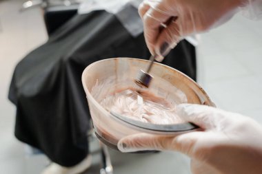 Kısa saçlı ve kısa saçlı güzel bir kız güzellik salonunda bir prosedür uyguluyor. Saç ustası müşterinin saçını boyuyor ve boyuyor. Yüksek kaliteli FullHD görüntüler