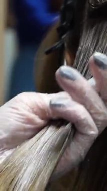 Kısa saçlı ve kısa saçlı güzel bir kız güzellik salonunda bir prosedür uyguluyor. Saç ustası müşterilere saç boyama ve tonu sunuyor. Yüksek kaliteli FullHD görüntüler