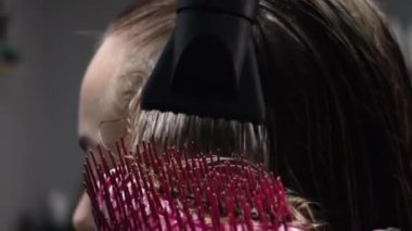 Kısa saçlı ve kısa saçlı güzel bir kız güzellik salonunda bir prosedür uyguluyor. Saç ustası müşterilere saç boyama ve tonu sunuyor. Yüksek kaliteli FullHD görüntüler