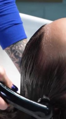 Kısa saçlı ve kısa saçlı güzel bir kız güzellik salonunda bir prosedür uyguluyor. Saç ustası müşterilere saç boyama ve tonu sunuyor. Yüksek kaliteli FullHD görüntüler