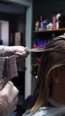 Kısa saçlı ve kısa saçlı güzel bir kız güzellik salonunda bir prosedür uyguluyor. Saç ustası müşterilere saç boyama ve tonu sunuyor. Yüksek kaliteli FullHD görüntüler