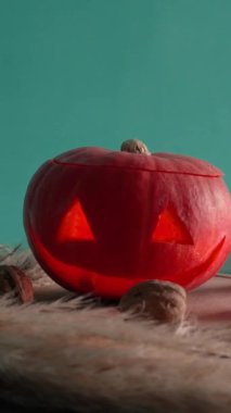 Cadılar bayramında balkabağı balkabağı parlar. Koyu arkaplanda portakal suyu ve balkabağı. Masada mumlar var. Hayaletler, korkular ve ruhlar bayramı için dekor. Yüksek kaliteli FullHD görüntüler