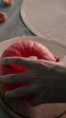 Cadılar bayramında balkabağı balkabağı parlar. Koyu arkaplanda portakal suyu ve balkabağı. Masada mumlar var. Hayaletler, korkular ve ruhlar bayramı için dekor. Yüksek kaliteli FullHD görüntüler