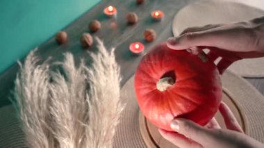 Cadılar bayramında balkabağı balkabağı parlar. Koyu arkaplanda portakal suyu ve balkabağı. Masada mumlar var. Hayaletler, korkular ve ruhlar bayramı için dekor. Yüksek kaliteli FullHD görüntüler