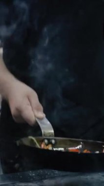 İtalyan şef fırında sebzeli makarna ve spagetti pişirir. Mutfakta tavadan bir sürü duman çıkıyor. Lezzetli bir yemek pişirme süreci