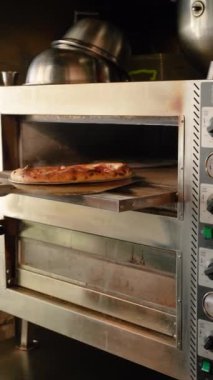 İtalyan pizzacısının fırınında pizza yapma süreci. Seyahat ve gastronomik kültür. Lezzetli ve iştah açıcı yemekler