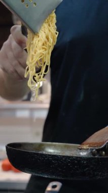 İtalyan şef fırında sebzeli makarna ve spagetti pişirir. Mutfakta tavadan bir sürü duman çıkıyor. Lezzetli bir yemek pişirme süreci