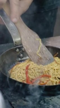 İtalyan şef fırında sebzeli makarna ve spagetti pişirir. Mutfakta tavadan bir sürü duman çıkıyor. Lezzetli bir yemek pişirme süreci
