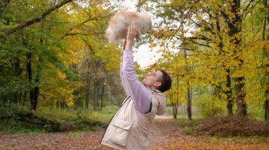 Parktaki genç sahibiyle yürüyüşe çıkmış sevimli tüylü köpek yavrusu. Köpek soyu Pomeranian Spitz. Ormanda sarı sonbahar yaprakları