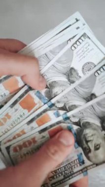 Masaya yakın plan 100 dolarlık banknotlar. Yatırım ve iş için para dolu cüzdan. Yatırımcı ve bankacı birikimlerini sayıyor