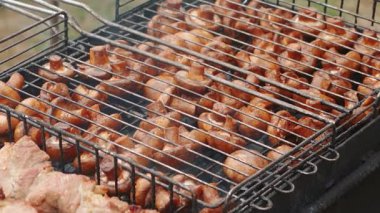 Lezzetli, iştah açıcı biftek eti dışarıda ateşte ve dumanda kızarıyor. Yaz tatilinde arkadaşlarla ızgarada şiş kebap. Kömürlü ızgara ızgara. Yüksek kalite FullHD