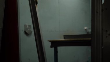 Hammaddeler ağır bir metal fabrikasının deposunda yatıyor. Metal levhalar bir fabrika işçisi tarafından yakın plan lazerle kesilir. Sanayi ve fabrika üretimi. Yüksek kaliteli FullHD görüntüler