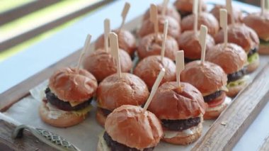 Amerikan yemekleri, hamburgerler büfede ve şölenler iş etkinliğinde. Hızlı ve kolay bir atıştırmalık için iştah açıcı fast food yemeği. Yüksek kaliteli FullHD görüntüler