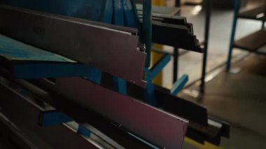 Hammaddeler ağır bir metal fabrikasının deposunda yatıyor. Metal levhalar bir fabrika işçisi tarafından yakın plan lazerle kesilir. Sanayi ve fabrika üretimi. Yüksek kaliteli FullHD görüntüler