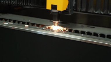 Ağır bir metal fabrikasında kaynak yaparken parlak kıvılcımlar uçuşuyor. Metal levhalar bir fabrika işçisi tarafından yakın plan lazerle kesilir. Sanayi ve fabrika üretimi. Yüksek kaliteli FullHD görüntüler