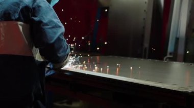 Ağır bir metal fabrikasında kaynak yaparken parlak kıvılcımlar uçuşuyor. Metal levhalar bir fabrika işçisi tarafından yakın plan lazerle kesilir. Sanayi ve fabrika üretimi. Yüksek kaliteli FullHD görüntüler