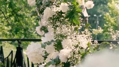 Gelin ve damadın düğün töreninden önce nehir kıyısında beyaz gül çiçeklerinin kemeri, romantik bir dekor. Yüksek kaliteli FullHD görüntüler