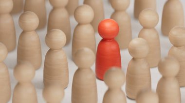 Ayrımcılık ve dahil etme kavramı. Ahşap heykelcikler, beyaz arka plandaki kırmızı 3D 'nin etrafını sarmıştı..