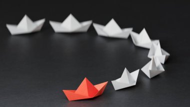 Farklı iş anlayışı. Yeni fikirler. Kağıt sanatı. Origami kağıt tekne filosu. Takım çalışması kavramı siyah arkaplan üzerinde 3D görüntüleme.