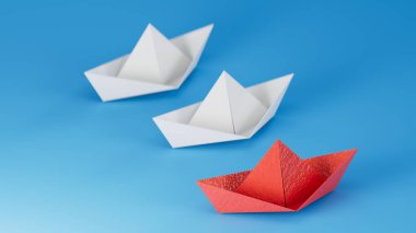 Kağıt tekneler. Yaratıcı yenilik ve lider teknesi ticari konsepti. Beyaz teknelerin önünde düz kırmızı origami lideri yatıyordu. Şirket stratejisi ve başarılı çözüm.