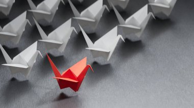 Farklı iş anlayışı. Kırmızı kağıt kuğu beyaz kağıt kuğudan yön değiştiriyor. Yeni fikirler. Kağıt sanatı. yaratıcı fikir. Siyah arkaplanda 3D görüntüleme.