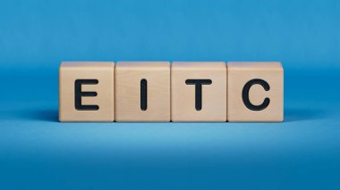 EITC iş sözcüğüyle tahta küp bloğu. Ahşap elementlerin kapatılması, mavi arkaplanda 3D İş Konsepti.