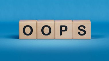 OPS iş sözcüğüyle tahta küp bloğu. Ahşap elementlere yakın plan, mavi arkaplanda 3D İş Konsepti.