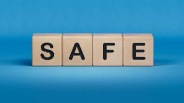 SAFE iş sözcüğüne sahip tahta küp bloğu. Ahşap elementlere yakın çekim, mavi arkaplanda 3D İş Konsepti.