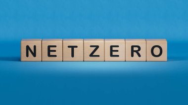 Karbondioksit salınımını azaltmak, iklim değişikliğini sınırlamak, küresel ısınma, net sıfır karbondioksit azaltımı kavramı. Yeşil Ağ Sıfır simgesi, mavi arkaplan üzerinde küçük tahta küp blok3D oluşturulmuş metin.