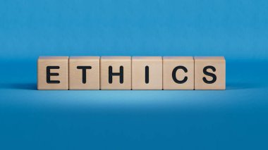 ETHICS üzerine beyaz not defteri, küp bloğu, hisse senedi konsepti. Ahşap elementlerin kapanışı, mavi arkaplanda 3D İş Konsepti.