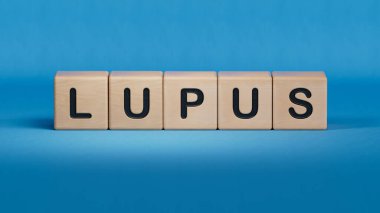 LUPUS kelimesi tahta küplere yazılır. Tıbbi konsept. Ahşap elementlere yakın çekim, mavi arka planda 3D iş konsepti..