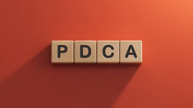 PDCA iş sözcüğüyle tahta küp bloğu. Ahşap elementlere yakın plan, kırmızı arkaplanda 3D İş Konsepti.