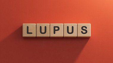 LUPUS kelimesi tahta küplere yazılır. Tıbbi konsept. Ahşap elementlere yakın çekim, kırmızı arka planda 3D İş Konsepti.